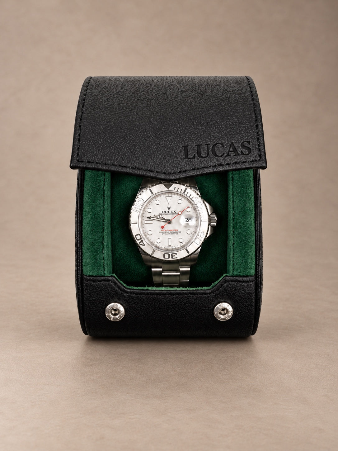 Holborn 1 noir et vert — vue de face avec une montre — personnalisation LUCAS sur le rabat — fond taupe